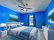 This bedroom features neutral carpeting, a ceiling fan, blue walls and furnishings and art at 14352 Pocono Ave, Port Charlotte, FL 33981