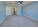 Spacious bedroom with neutral carpet, light blue walls, and ceiling fan at 14352 Pocono Ave, Port Charlotte, FL 33981