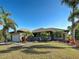 A single-Gathering home with lush landscaping, a covered entry, and an attached garage at 14352 Pocono Ave, Port Charlotte, FL 33981
