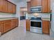 A well-equipped kitchen featuring stainless steel appliances and tile floors that extends to the dining area at 14352 Pocono Ave, Port Charlotte, FL 33981