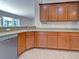 Well-lit kitchen features granite counters, stainless dishwasher, sink and matching cabinets with tile flooring at 14352 Pocono Ave, Port Charlotte, FL 33981