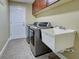 Clean and modern laundry room features matching washer and dryer and utility sink at 14352 Pocono Ave, Port Charlotte, FL 33981