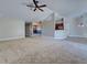 Open concept living room showcasing carpet floors, ceiling fan, and view to the kitchen and dining room at 14352 Pocono Ave, Port Charlotte, FL 33981
