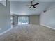 Spacious living room features plush carpeting, vaulted ceilings, ceiling fan, and sliding glass doors to the lanai at 14352 Pocono Ave, Port Charlotte, FL 33981