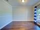 Cozy living room with wood floors, crown molding, and a large window offering natural light at 14352 Pocono Ave, Port Charlotte, FL 33981
