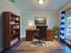 This beautiful home office features a wood desk, hardwood floors, a bookshelf, and a picturesque view from the window at 14352 Pocono Ave, Port Charlotte, FL 33981
