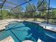 Sparkling pool with screen enclosure and decorative tile accents, perfect for outdoor relaxation and entertainment at 14352 Pocono Ave, Port Charlotte, FL 33981