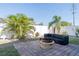 Outdoor patio with a fire pit and seating area surrounded by green trees and a white privacy fence at 1440 Overbrook Rd, Englewood, FL 34223