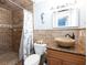 Stylish bathroom featuring stone tile shower, granite vanity, and decorative seahorse accent at 1440 Overbrook Rd, Englewood, FL 34223