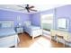 Bright bedroom features two twin beds, a window with natural light, and light purple walls at 1440 Overbrook Rd, Englewood, FL 34223