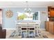 Dining room with a white table set and a large window overlooking the yard and landscaping at 1440 Overbrook Rd, Englewood, FL 34223