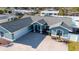 Charming single-story home with lush landscaping, a gravel driveway, and an inviting entrance at 1440 Overbrook Rd, Englewood, FL 34223
