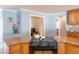 Kitchen with a black ceramic cooktop, wood cabinets, granite countertops, and blue walls at 1440 Overbrook Rd, Englewood, FL 34223