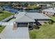 Waterfront home featuring a two-car garage and a well-manicured lawn with direct access to the canal at 1503 Marlin St, Nokomis, FL 34275