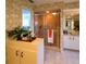 Well-appointed bathroom featuring a walk-in shower, vanity, and a neutral patterned wallpaper at 1611 Valley Dr, Venice, FL 34292
