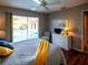 Bright bedroom boasts pool access, a comfortable bed, and a white dresser at 1611 Valley Dr, Venice, FL 34292