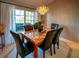 Formal dining room featuring marble table, elegant chandelier, and natural light from the window at 1611 Valley Dr, Venice, FL 34292