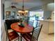 Dining area with wood table, seamlessly connected to the living room and outdoor pool area at 1611 Valley Dr, Venice, FL 34292