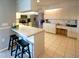 Functional kitchen with breakfast bar, white cabinets, and open layout leading to the dining area at 1611 Valley Dr, Venice, FL 34292