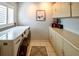 Laundry room featuring side-by-side machines, tile floor, and ample counterspace and storage at 1611 Valley Dr, Venice, FL 34292