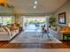 Bright living room with hardwood floors and sliding glass doors overlooking a sparkling pool at 1611 Valley Dr, Venice, FL 34292