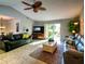 Sunlit living room featuring tile flooring, a ceiling fan, and sliding door access to the outdoors at 1611 Valley Dr, Venice, FL 34292