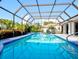 Inviting screened-in pool area surrounded by lush tropical landscaping for privacy at 1611 Valley Dr, Venice, FL 34292