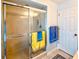 Close up of shower featuring glass doors with colorful towels, and a neutral tile floor at 1611 Valley Dr, Venice, FL 34292