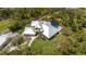 Expansive aerial view showcases the home's metal roof, pool, and lush greenery in a private, wooded setting at 1657 Bayshore Dr, Englewood, FL 34223
