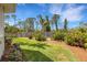 The backyard features a lush green lawn, landscape beds, mulch and a wooden fence around the perimeter at 1657 Bayshore Dr, Englewood, FL 34223