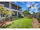 A large backyard features a lawn and trees with a screened lanai and balcony on the rear of the home at 1657 Bayshore Dr, Englewood, FL 34223