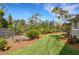 A serene backyard featuring lush landscaping, a well-maintained lawn, and beautiful tropical plants at 1657 Bayshore Dr, Englewood, FL 34223