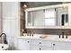Bathroom with white cabinets, dual sinks, modern fixtures, and a large framed mirror at 1657 Bayshore Dr, Englewood, FL 34223
