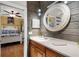 Bright bathroom boasts wood-look wall, granite counter, sink, and doorway to bedroom at 1657 Bayshore Dr, Englewood, FL 34223
