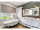 Modern bathroom with a standalone tub, dual vanity, wood paneling, and elegant lighting at 1657 Bayshore Dr, Englewood, FL 34223