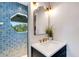 Stylish bathroom features blue tile shower, modern vanity and mirror at 1657 Bayshore Dr, Englewood, FL 34223