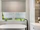 Bathroom featuring a freestanding tub, modern vanity, and views of backyard at 1657 Bayshore Dr, Englewood, FL 34223