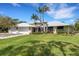 Exterior front view of home with multiple garage doors, landscaping, and prominent palms at 1657 Bayshore Dr, Englewood, FL 34223