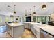Spacious kitchen with white countertops, a farmhouse sink, stainless steel appliances, and an island for extra prep space at 1657 Bayshore Dr, Englewood, FL 34223