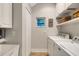 Efficient laundry room features washer, dryer, storage cabinets, shelving and a sink at 1657 Bayshore Dr, Englewood, FL 34223
