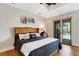Well-lit bedroom featuring hardwood floors, neutral colors, and a door leading to the backyard at 1657 Bayshore Dr, Englewood, FL 34223