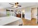 Bright main bedroom with hardwood floors, ceiling fan, balcony access, and ensuite bathroom at 1657 Bayshore Dr, Englewood, FL 34223