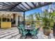 Stylish outdoor table and chairs under pergola next to a tiki bar offer entertainment space at 1657 Bayshore Dr, Englewood, FL 34223