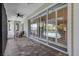 Spacious covered patio featuring brick flooring, a ceiling fan, and large glass doors leading inside at 1657 Bayshore Dr, Englewood, FL 34223