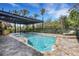 Lush pool with tropical pergola offers a private oasis with outdoor seating at 1657 Bayshore Dr, Englewood, FL 34223