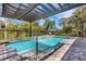 Inviting pool with tanning ledge and soothing water feature surrounded by brick pavers at 1657 Bayshore Dr, Englewood, FL 34223