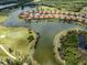 An aerial view of a residential community on a lake, with a golf course in the background at 177 Treviso Ct, North Venice, FL 34275