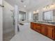Luxurious bathroom featuring dual vanities, a modern soaking tub, glass block window, and a separate glass-enclosed shower at 177 Treviso Ct, North Venice, FL 34275