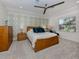 Serene bedroom with a wood frame bed, patterned wallpaper, and ample natural light creates a relaxing ambiance at 177 Treviso Ct, North Venice, FL 34275