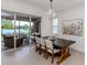 Dining room with view of lake and sliding glass door to screened lanai at 177 Treviso Ct, North Venice, FL 34275